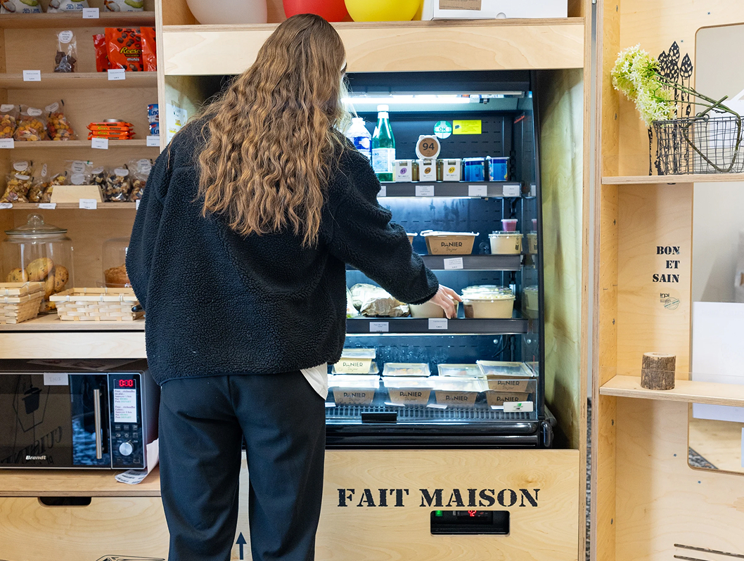Étudiante choisissant un sandwich dans un distributeur de la cafétéria du campus de Rennes de l’école de commerce ECE