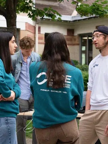 ECE ambassadors interacting with two visitors during an open house on the Paris campus.