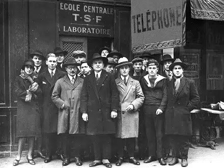 Archive de l’École Centrale de T.S.F. montrant élèves et enseignants devant le laboratoire de la rue de la Verrerie à Paris. Au centre figure Eugène Poirot en tenue sombre, enseignant dans l’établissement depuis 1924 avant d’en prendre la direction en 1926. Source : collection personnelle de M. Pierre Mouchel.