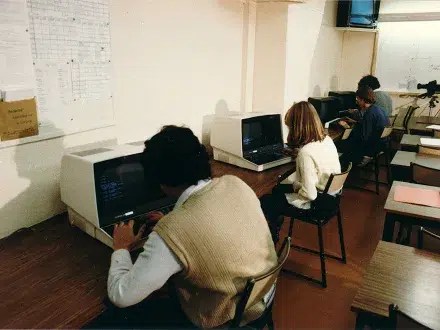 Archive des locaux de l’ECE datant des années 1990, montrant des élèves sur des postes informatiques dans la salle d’informatique et d’électronique. Source : collection E.C.E.